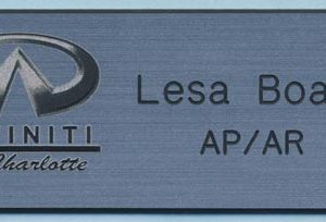 silver name tag with black engrave logo and text