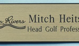 gold name tag with engraved logo and text