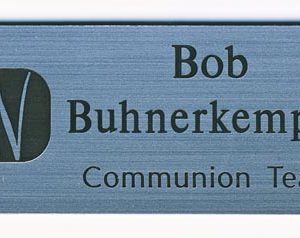 silver engraved name tag with black logo and text