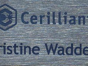 silver metallic name tag with blue engraved logo and text