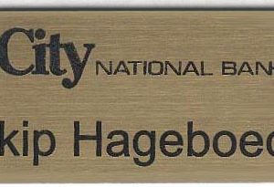 gold metallic name tag with black engraved text and logo