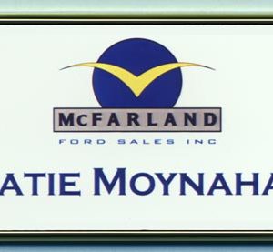 white full color name tag in a silver frame with printed logo and text