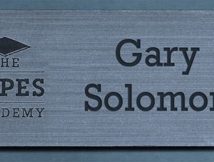 metallic silver name tag with black engraved logo and text