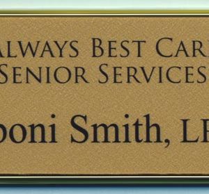 Gold framed name tag with printed logo and text