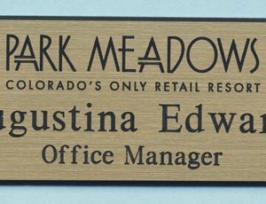 Gold engraved name tag with black logo and text