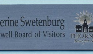 Engraved silver tag with blue engrave logo and text