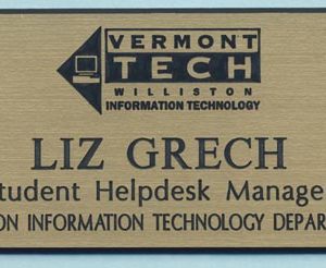 Gold engraved name tag with black logo and text