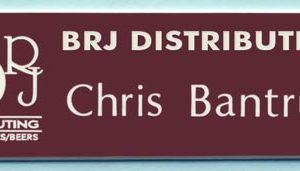Engraved burgundy name tag with white logo and text