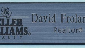 Engraved silver/black name tag with logo and text