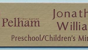 Engraved gold name tag with burgundy logo and text
