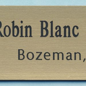 Engraved gold name tag with black logo and text