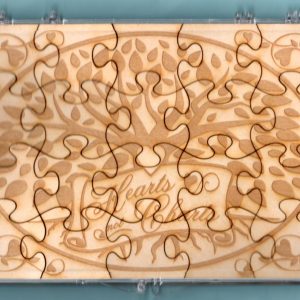 Laser-engraved birch wood LDS family history puzzle featuring the words "Hearts Not Charts" & graphics